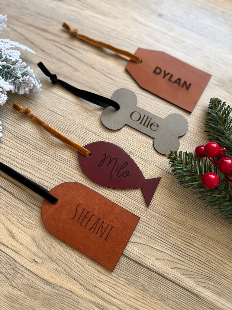 Personalized name tags on a wooden surface with decorative elements.